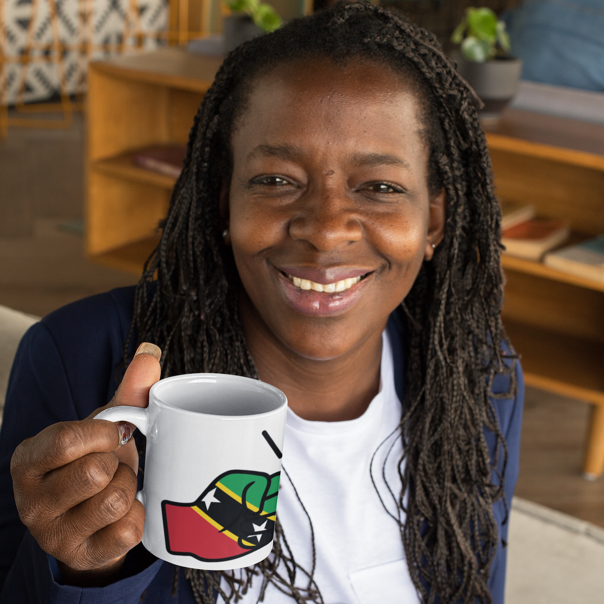 Woman holding a We Run Tings, St Kitts, Kittitians & Nevisians Caribbean Themed mug with a design, sitting in a room with furniture and decor.