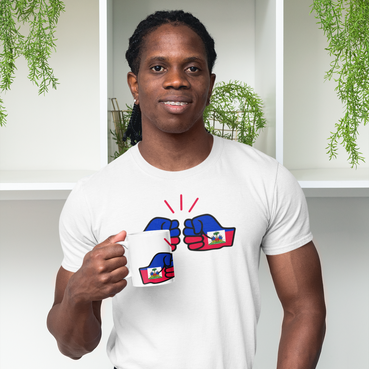 Man holding anWe Run Tings and white t-shirt Haiti themed items from the brand