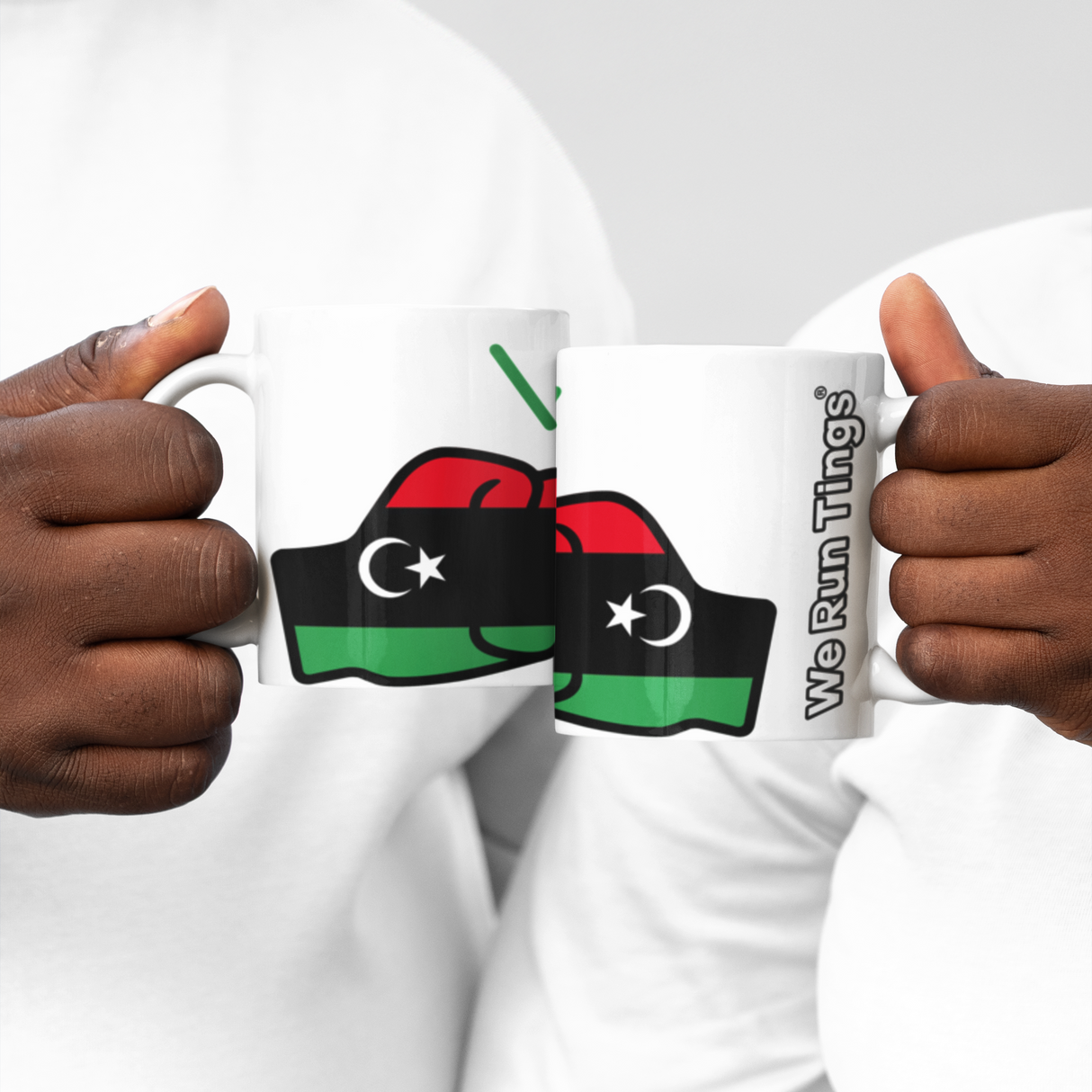 Two people holding We Run Tings Libya white ceramic mugs with a flag design and text on a white background