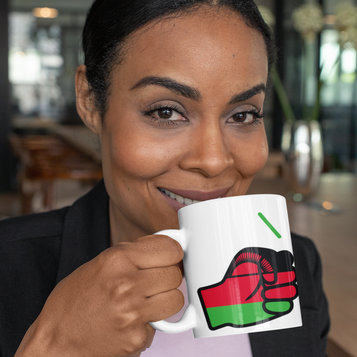 Woman holding a We Run Tings Malawi tea, coffee mug, cup with a fist design featuring the We Run Tings logo in a casual setting