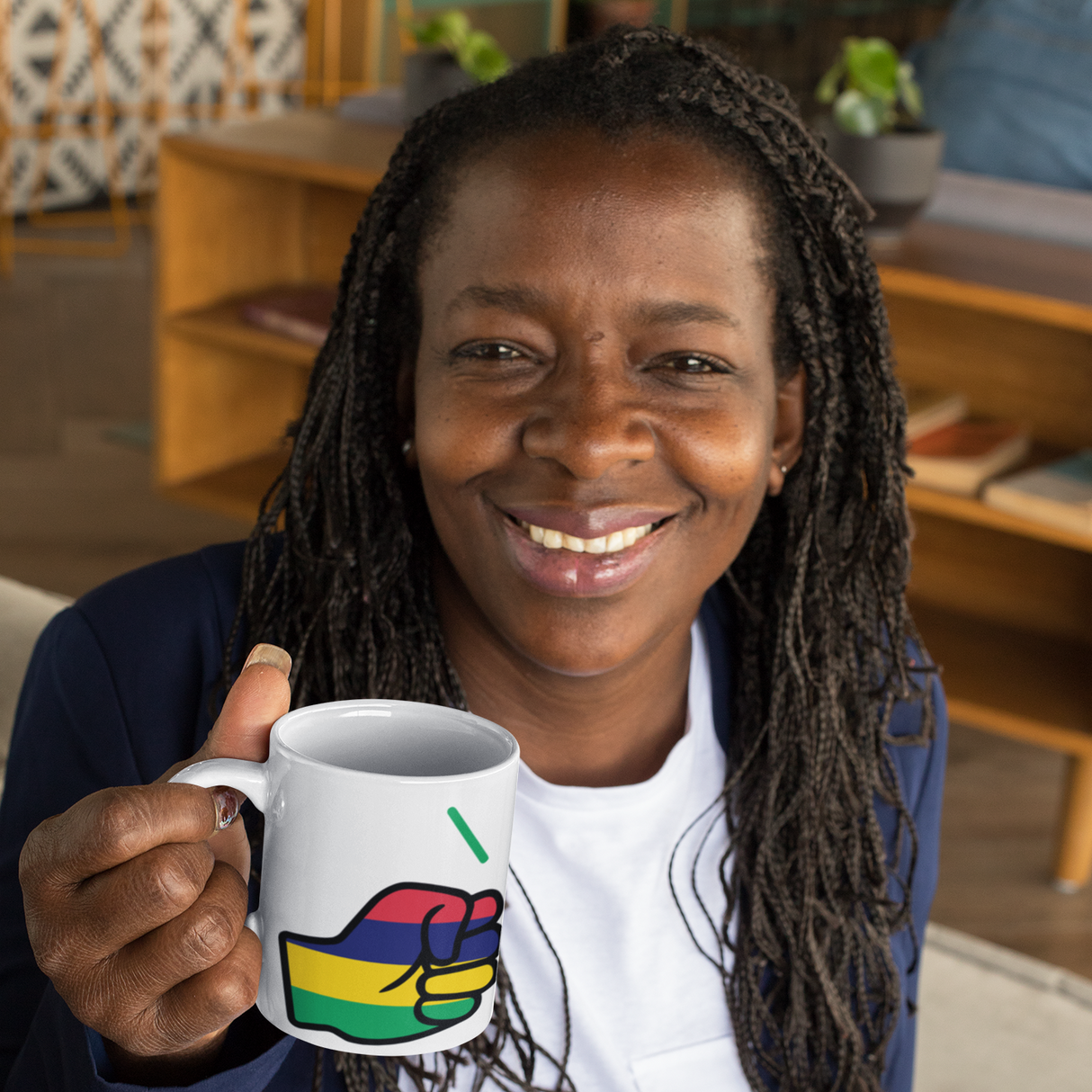 Woman holding a white ceramic We Run Tings Mauritius tea, coffee, mug, cup with a colorful design, sitting in a cozy room.