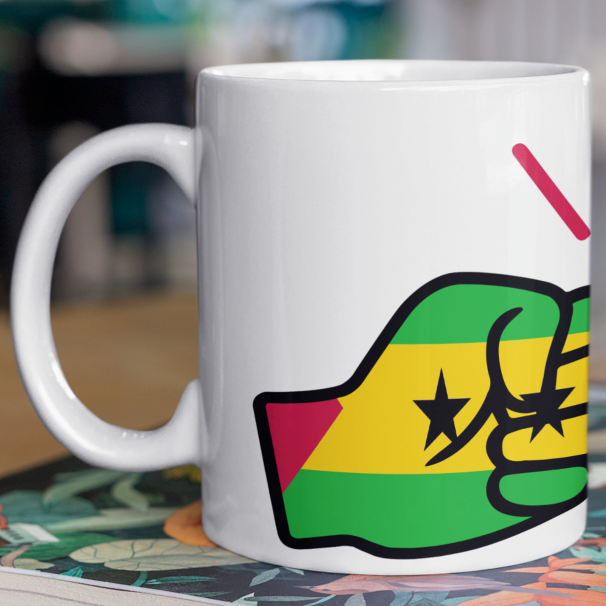 White mug with a colorful design on a stack of books. São Tomé and Príncipe We Run Tings mug. Premium white 11oz ceramic mug featuring the flag design. Dishwasher & microwave safe. Side view