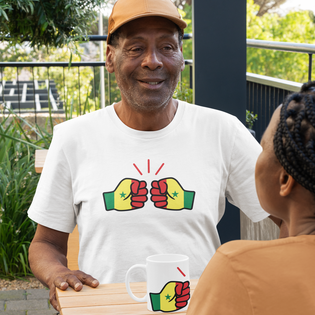 African Man wearing a white We Run Tings, Senegal themed t-shirt with a graphic white Senegal themed design, standing outdoors with another African woman.
