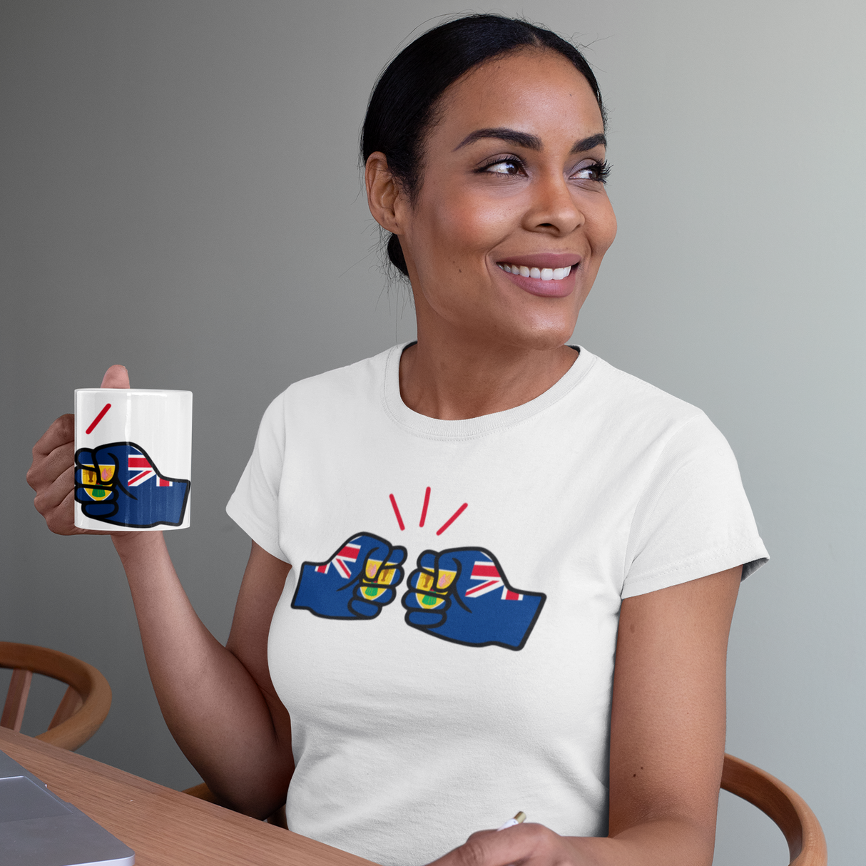 Woman holding a We Run Tings, Turks and Caicos, Caribbean Themed, Tea, Coffee Ceramic Mug, Cup, White, 11oz Classic Drinkware Washable Reusable Reuse Tumbler Patriotic, wearing a white t-shirt with similar designs, sitting at a table.