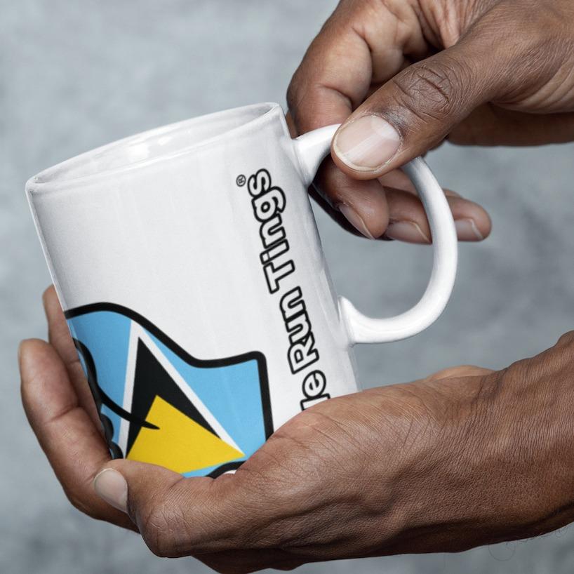 Person holding a white We Run Tings, St Lucia, St. Lucian Caribbean Themed, Tea, Coffee Ceramic Mug, Cup, 11oz Classic Drinkware Washable Reusable Reuse Glossy Tumbler Patriotic mug with a logo and text on a gray background