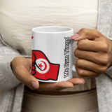 Person holding a white coffee mug with the flag of Tunisia.