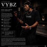 Man in a recording studio wearing a VYBZ shirt with promotional text about the brand.