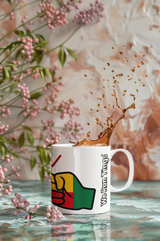 Mug with a raised fist logo and We Run Tings text and Benin flag filled with coffee, with pink flowers in the background.