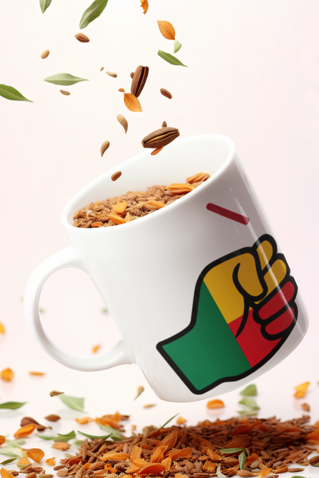 White mug with a We Run Tings Benin flag fist design filled with granola with scattered granola on a light background.