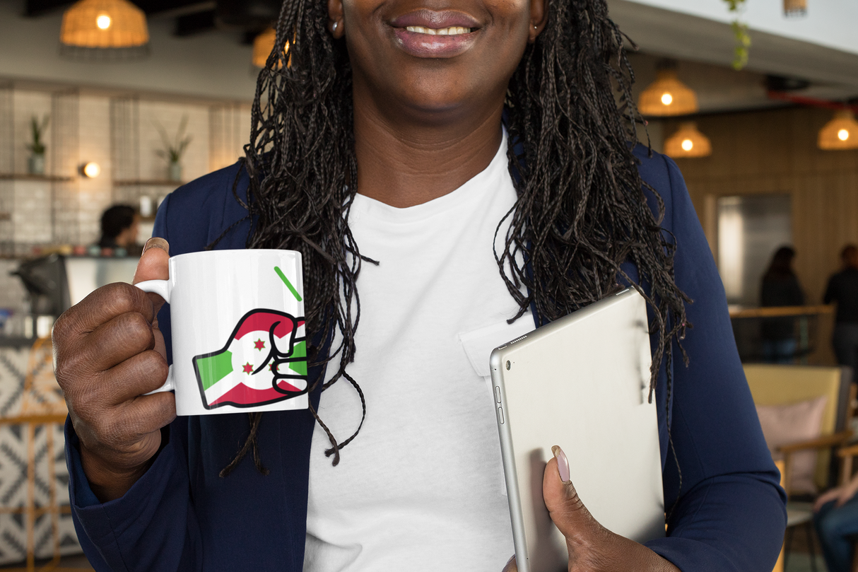 Woman holding a mug with a Burundi flag and We Run Tings logo and a tablet in an indoor setting