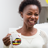 Woman smiling holding a We Run Tings Uganda themed mug with a colorful design, smiling in a casual setting.