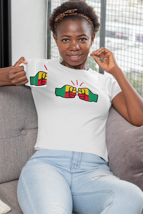 Woman wearing a white t-shirt with a We Run Tings logo and Benin flag colorful design, sitting on a couch.