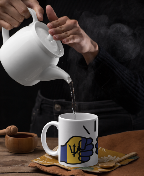 Woman pouring hot water into a white ceramic Barbados themed mug