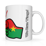 Side view. White mug with a graphic fist of the flag of Burkina Faso Mug. White ceramic glossy cup featuring the flag of Burkina Faso graphic and 'We Run Tings' text on a white background