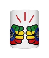 A glossy white We Run Tings Ethiopia Mug ceramic mug with a graphic design of fists in different colors on the side. On a white background