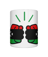 A glossy white ceramic mug We Run Tings Libya mug with a graphic design featuring clenched fists and the colours of the Libyan flag. Front view on a white background