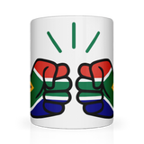 A glossy white ceramic We Run Tings, South Africa mug with a graphic design of two clenched fists and the South African flag. Front view.