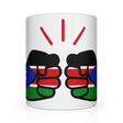 A white We Run Tings ceramic mug with a glossy finish featuring a graphic design of clenched fists and the flag of South Sudan. Front view.