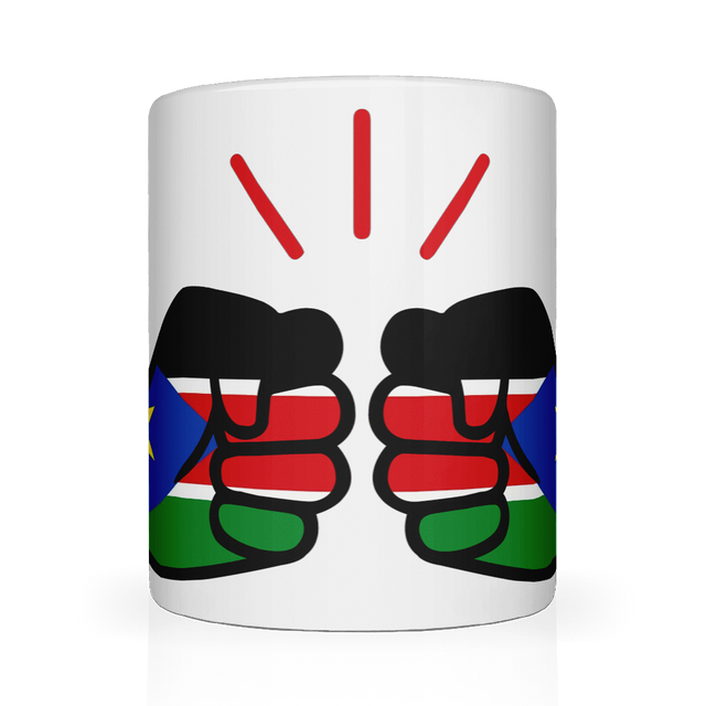 A white We Run Tings ceramic mug with a glossy finish featuring a graphic design of clenched fists and the flag of South Sudan. Front view.