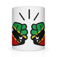A white ceramic mug with a glossy finish featuring a graphic design of two clenched fists in green, yellow, and red, representing St. Kitts and Nevis, with a background of stars.