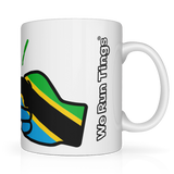 White We Run Tings, Tanzania tea, coffee ceramic mug, cup featuring the flag of Tanzania within the We Run Tings fist logo on a white background. Side view showing the wording of the brand name