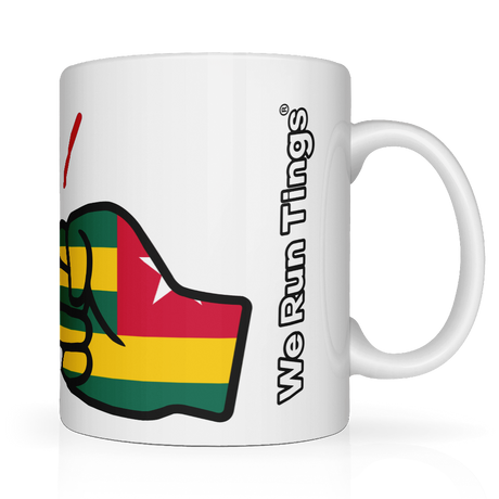 White ceramic “We Run Tings” mug featuring a raised fist wrapped in the Togo flag colors, with the brand name printed vertically on the side, symbolizing empowerment, unity, and cultural pride.