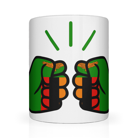 A white We Run Tings, Zambia ceramic mug with a graphic design of a fist holding a tea bag, surrounded by a green and red pattern. Front view